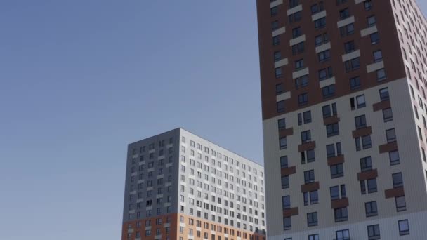 Novo edifício alto colorido moderno no fundo do céu azul. Acção. Vista inferior de uma casa de vários andares, ampliação do conceito de limites da cidade. — Vídeo de Stock