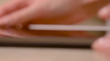 Masada tablet kullanan bir adamın yakın çekimi. Kavram. Bulanık arkaplanda yeni tablet kullanılıyor. Uygulamaları açmak için dokunmatik tablete tıklayın