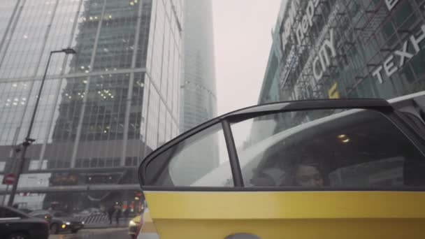 Biznesmenka wysiadająca z samochodu na ulicy z wysokimi budynkami. Akcja. Widok z dołu pięknej białej kobiety w średnim wieku w brązowym płaszczu pozostawiając samochód lub taksówkę na tle — Wideo stockowe