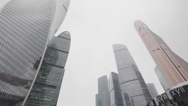 Rascacielos de cristal modernos vistos desde abajo hacia arriba. Acción. Hermoso distrito de negocios en el centro de la ciudad en un clima de niebla. — Vídeos de Stock