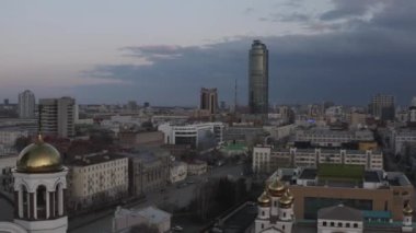 Azizler, Rusya ve Ekaterinburg adına Kan Kilisesi. Stok görüntüleri. Altından kubbeleri ve arka planında Vysotsky gökdeleni olan güzel bir kilisenin akşam manzarası.