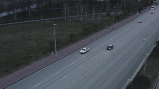 Вид с воздуха на автомобили на шоссе. Запись. Многополосные автомагистрали с движущимися автомобилями вдоль зеленого летнего луга. — стоковое видео