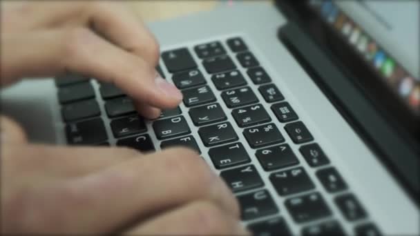 노트북의 키보드로 온라인 작업을 하고 있습니다. 자료 화면이요. 키보드에서 문자를 입력하는 남성 손을 닫고 손가락으로 버튼을 눌러. — 비디오
