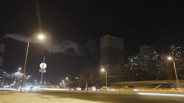 Caducidad del camino nocturno de invierno en la zona de noche de la ciudad. Acción. Paisaje de ciudad oscura con chimenea humeante y casas residenciales. — Vídeo de stock