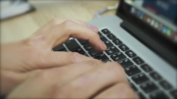 Trabalhando online no teclado de um laptop. Imagens de stock. Fechar as mãos masculinas digitando texto no teclado, pressionando os botões com os dedos. — Vídeo de Stock