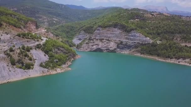 Vista aérea del increíble lago azul rodeado de rocas. Clip. Hermosa agua turquesa de un gran lago y montañas boscosas. — Vídeos de Stock