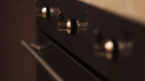 Feche o foco em movimento nas alças do fogão a gás preto na cozinha. Conceito. Utensílios de casa e alimentos para cozinhar em casa. — Fotografia de Stock