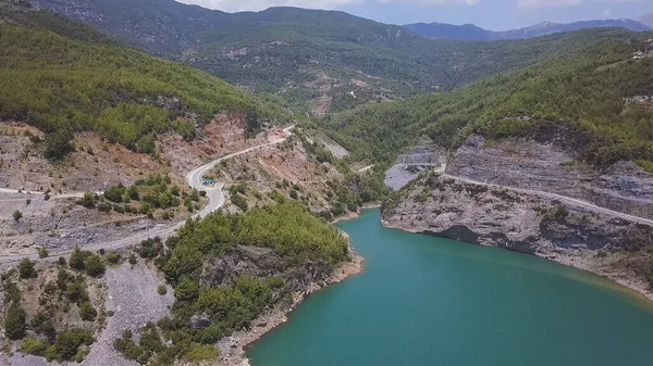 Uitzicht vanuit de lucht op een prachtig blauw meer omringd door rotsen. Een knip. Prachtig turkoois water van een groot meer en beboste bergen. — Stockfoto
