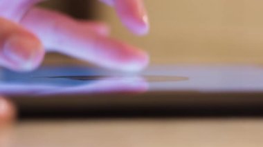 Resim yapmak için tablet kullanan bir kadının fotoğrafını çek. Kavram. Sayısal sanatçı, parmaklarıyla zumluyor ve beyaz bir stil ile resim boyuyor.. 