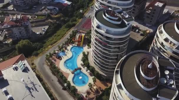 Güzel bir yüzme havuzu olan bir otel kompleksinin havadan görünüşü. Şarjör. Konut evleri, yeşil bitki örtüsü ve lüks otelleri olan modern güney şehri, tatil kavramı. — Stok video