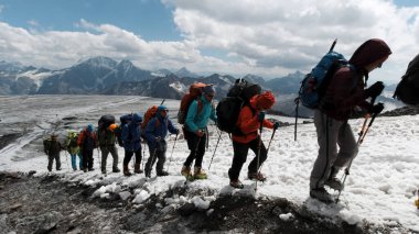 Bir grup dağcı, Mt. Dağın buzlu yamacına tırmanıyor. Everest gökyüzünde. Şarjör. İnsanlar karlı bir yola tırmanmaktan zevk alıyor..