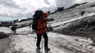 Bir grup dağcı, Mt. Dağın buzlu yamacına tırmanıyor. Everest gökyüzünde. Şarjör. İnsanlar karlı bir yola tırmanmaktan zevk alıyor..