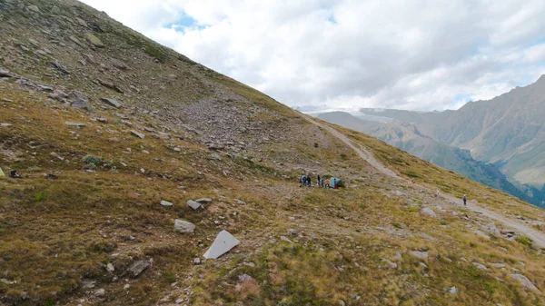 Tourist camp in mountains. Clip. Groups of active tourists make stop on mountain trails for recreation. Camp for tourists climbing mountains in cloudy weather in summer