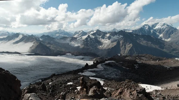 Karlı vadide ve karlı vadide devasa bir kar dağı manzarası var. Şarjör. Karlı zirveleri ve yüksek kayaları olan nefes kesici bir manzara.. — Stok fotoğraf