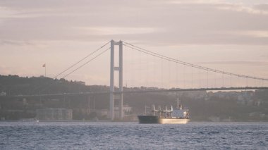 Geniş bir nehir, köprü ve küçük yelkenli bir gemiyle çok güzel doğal bir arka plan. Başla. Suyun üzerinde sabah bulanıklığı ve güzel bir köprü. 