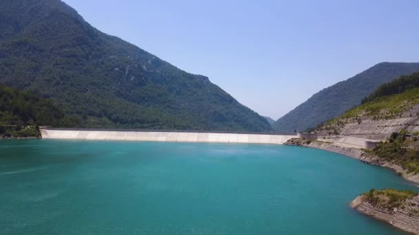 Vista aérea del agua turquesa en un lago de bosque de montaña. Clip. Paisaje turco con depósito de agua de color azul sobre el fondo del cielo azul y colinas boscosas. — Vídeo de stock