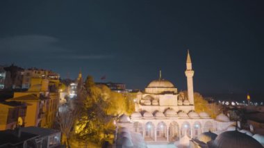 Gece şehrinin arka planında güzel bir cami. Başla. Fenerlerle aydınlatılmış, İstanbul 'un arka planında cami var. Aydınlatılmış camilerle İstanbul 'un akşam manzarası