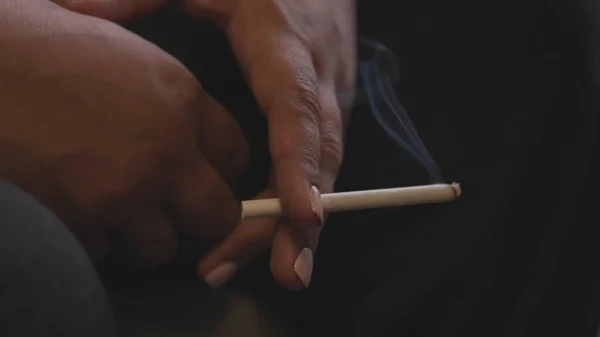Sigara içen 50 yaşındaki bir kadının elini yakın çekim. Stok görüntüleri. Beyaz manikürlü, sigara içen, yorgunluk kavramı olan yaşlı bir kadının elleri.. — Stok fotoğraf