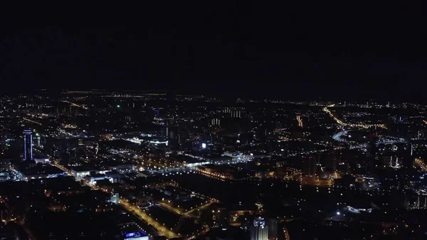 Escena nocturna vista aérea de una gran ciudad sobre fondo de cielo negro. Imágenes de archivo. Hermosas luces iluminando largas calles contrastando con el cielo negro. — Foto de Stock