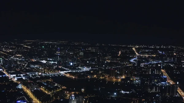 밤하늘에 검은 색으로 뒤덮여 있는 한 대 도시의 야간 공중 풍경. 자료 화면이요. 검은 하늘과 대조되는 긴 거리를 밝혀 주는 아름다운 불빛. — 스톡 사진