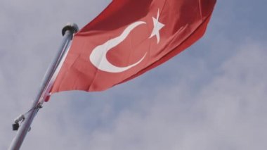 Parlak mavi arka planda Türk bayrağı dalgalanıyor. Başla. Rüzgarda sallanan kızıl bir Türk 'ün alt görüntüsü.. 