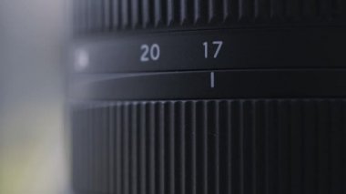 Siyah dijital kamera lensinin yakınlaştırma ölçeğini kapat. Başla. Bulanık arkaplanda profesyonel fotoğraf ekipmanlarının detaylarını kapat.