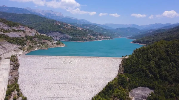 Luchtfoto van turquoise water in een bergmeer. Een knip. Turks landschap met waterreservoir van azuurblauwe kleur op de achtergrond van blauwe lucht en beboste heuvels. — Stockfoto