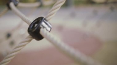 Boş bir çocuk parkındaki beyaz iplerden oluşan ağı kapat. Başla. Çocukluk ve eğlence kavramı, yeni spor aletleri. 