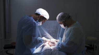 Ameliyathanedeki cerrahlar bir hastayı ameliyat ediyorlar. Başla. Hastanedeki gerçek bir tıbbi ameliyatın yan görüntüsü..