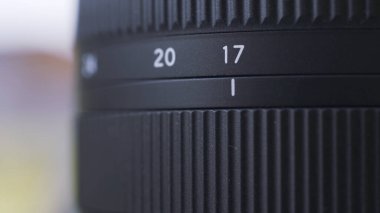 Siyah dijital kamera lensinin yakınlaştırma ölçeğini kapat. Başla. Bulanık arkaplanda profesyonel fotoğraf ekipmanlarının detaylarını kapat.