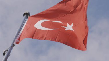 Parlak mavi arka planda Türk bayrağı dalgalanıyor. Başla. Rüzgarda sallanan kızıl bir Türk 'ün alt görüntüsü.. 