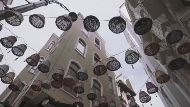 Alsó kilátás gyönyörű fonott kosarak náci amulettek lóg a város utcáin épületek között. Felvétel. Narrow street details, Isztambul, Törökország. — Stock videók