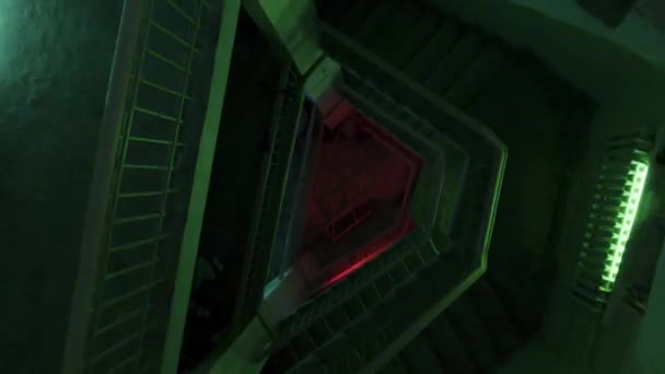Bovenaanzicht van trappen onder kleurrijke knipperende lichten. Voorraadbeelden. Donkere trap met groene, paarse en blauwe feestverlichting. — Stockvideo