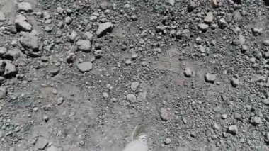 Dağdan inen kayalıklarda kayıp düşen yürüyüşçü botları içinde. Şarjör. Elinde bir direkle yürüyen bir dağcının ilk kişi görüntüsü..