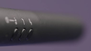 Ses kayıt stüdyosunda mikrofon kaydediliyor. Başla. Mikrofon çubuğunda, eflatun duvar arka planında izole edilmiş düğmeler ile hareket eden odağı kapat. 