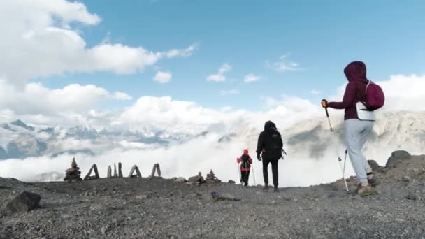 Rückansicht von Reisenden, die mit Stöcken einen Berghang erklimmen. Clip. Extremsport und aktiver Lebensstil, um die Schönheit der Welt zu erkunden. — Stockvideo