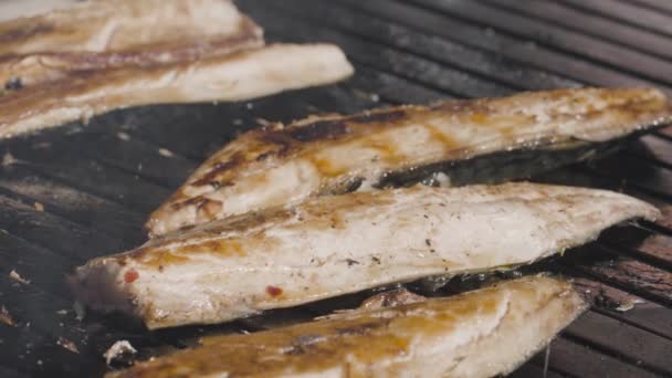 Primo piano del pesce grigliato. Azione. Il pesce pelato con carne tenera viene cotto alla griglia. Il pesce succoso e saporito è grigliato su griglia. Cucinare pesce fresco alla griglia — Video Stock