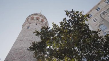 Şehirdeki eski kulenin altından bak. Başla. Şehrin merkezinde mavi gökyüzünün arka planında antik kule yükseliyor. Antik şehrin manzaraları