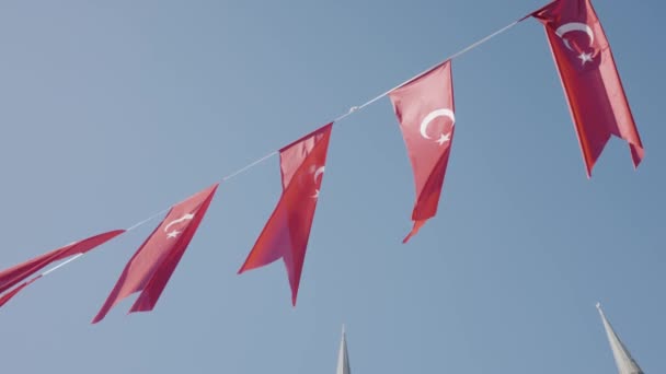 Turkse vlaggen aan touw. Actie. Vlaggen van Turkije hangen feestelijk aan touw op de achtergrond van de blauwe lucht. Vlaggen van Turkije hangen prachtig en zwaaien in de wind. Turkse feestdagen en patriottisme — Stockvideo