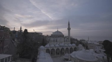 Akşamları beyaz cami ve deniz manzarası, zaman aşımı. Başla. Müslüman camii olan bir deniz manzarası ve bulutlu arka planda bir şehir.. 