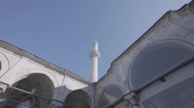 Beyaz tapınağın alt görüntüsü kemerli ve uzun kuleli. Başla. Mavi gökyüzü arkaplanındaki güzel tarihi bina.