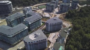 Yeşil bitki örtüsü ve binalarla çevrili açık havuzu olan büyük bir otel kompleksinin havadan görüntüsü. Şarjör. Yaz tatili ve tatil kavramı.