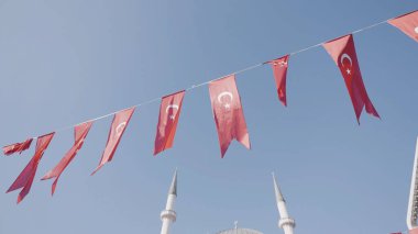 Türkiye, İstanbul-Aralık 2020: Mavi arka planda Türk bayrakları. Başla. Rüzgarda dalgalanan Türk bayraklarıyla şenlikli kurdele. Türk bayrakları minarelerin arka planında şenlikli ipe asılıyor