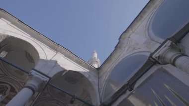 Beyaz tapınağın alt görüntüsü kemerli ve uzun kuleli. Başla. Mavi gökyüzü arkaplanındaki güzel tarihi bina.