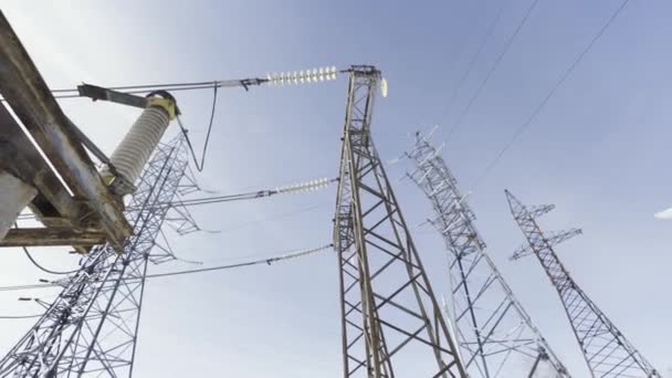 Torres de eletricidade no fundo do céu azul, vista inferior. Acção. Linha de transmissão de energia, conceito de fornecimento de energia da cidade. — Vídeo de Stock