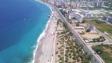 Sabah panoramik deniz ve sahil manzarası, hava aracı manzarası. Şarjör. Uzun kıyı şeridi ve kumlu plajı olan modern bir tatil köyü, uzun düz bir yolu olan güney şehri.. 