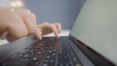 Laptop klavyesinde daktilo eden adama yakın çekim. Başla. Dizüstü bilgisayarda mektup ya da tez basmak. Adam beceriksizce dizüstü bilgisayarla yazı yazıyor.