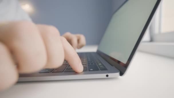 ノートパソコンのキーボードで入力している人のクローズアップ。行動だ。ノートパソコンで文字や論文を印刷する。男は専門外のタイプの彼の指でラップトップ — ストック動画