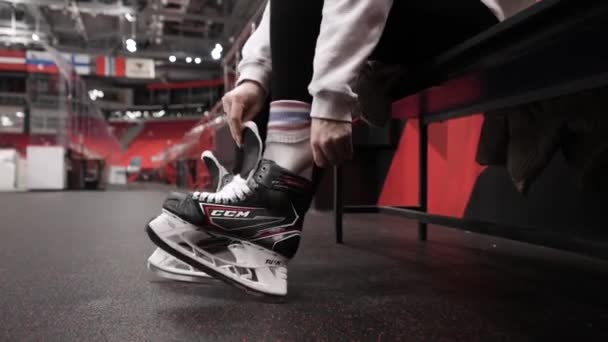 Moskva, Ryssland - december 2020: Hockeyspelare sätter på skridskor. Börja. Närbild av professionell hockeyspelare sätta på skridskor i omklädningsrummet. Ensamstående hockeyspelare förbereder i omklädningsrum för — Stockvideo