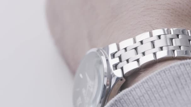 Primer plano de la muñeca masculina con un reloj caro hecho de oro blanco. Acción. Concepto de un exitoso hombre de negocios y accesorios. — Vídeos de Stock